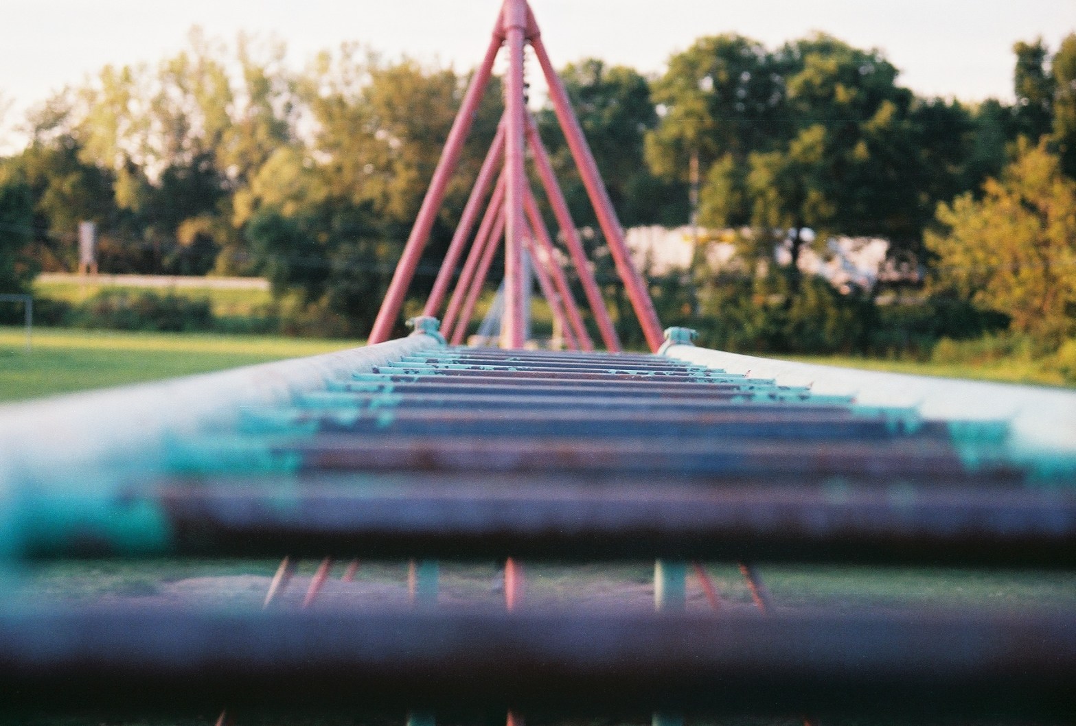 Photo looking across the top of monkey bars in a playground